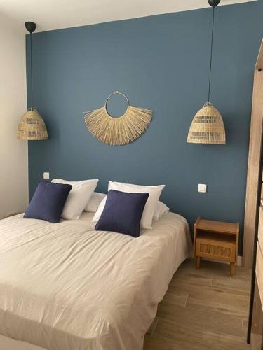 - une chambre avec un lit blanc et deux murs bleus dans l'établissement Cassis centre, superbe appartement neuf, 50m port., à Cassis