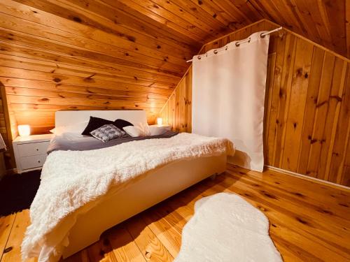 a bedroom with a bed in a wooden cabin at Ranczo Wilkowyja in Wilkowyja