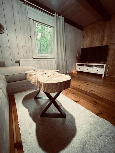 a living room with a wooden table and a television at Ranczo Wilkowyja in Wilkowyja