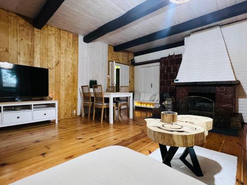 ein Wohnzimmer mit einem TV und einem Tisch mit einem Sofa in der Unterkunft Ranczo Wilkowyja in Wilkowyja