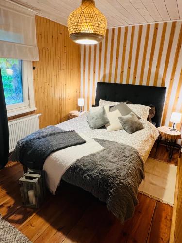 a bedroom with a large bed and a chandelier at Ranczo Wilkowyja in Wilkowyja