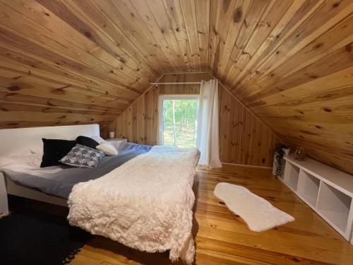 WilkowyjaにあるRanczo Wilkowyjaの木製の部屋に大型ベッドが備わるベッドルーム1室が備わります。
