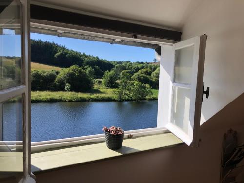 a window with a view of a river at La Dernière Étape in Port-Launay
