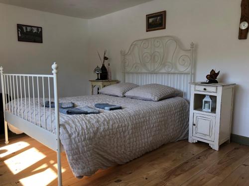 a bedroom with a white bed and a night stand at La Dernière Étape in Port-Launay