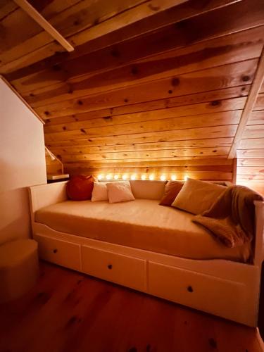 a bed in a room with a wooden ceiling at Ranczo Wilkowyja in Wilkowyja