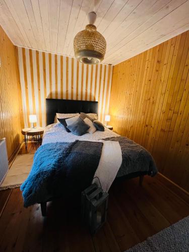 a bedroom with a bed in a wooden wall at Ranczo Wilkowyja in Wilkowyja