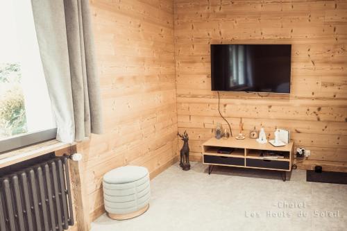 a room with a television in a wooden wall at Appartement Chalet Les hauts du soleil in Chamonix-Mont-Blanc