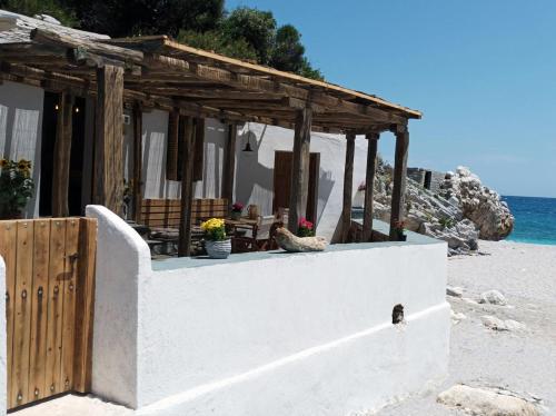 a small building on a beach with the ocean at Κυμοθόη in Milopotamos