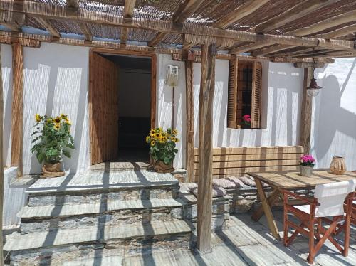 a porch of a house with a table and flowers at Κυμοθόη in Milopotamos