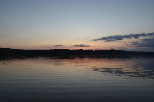 a view of a large body of water at sunset at Ferienzimmer am Berzdorfer See Görlitz OT Tauchritz in Görlitz