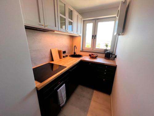 a small kitchen with a sink and a window at Apartament M.55 in Gdynia