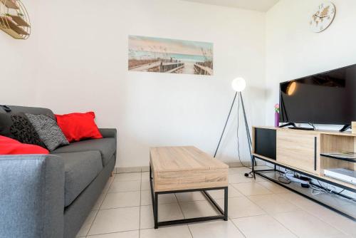 a living room with a couch and a tv at La loge du Minotaure, parking et bureaux in Toulouse