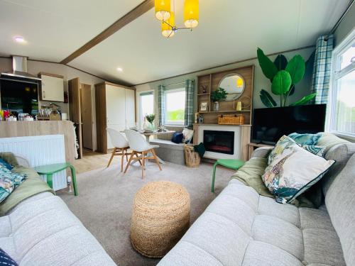 a living room with a couch and a tv at The Sanctuary Holiday Home - Escape the Ordinary in Knaresborough
