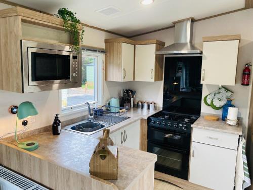 a kitchen with a sink and a stove at The Sanctuary Holiday Home - Escape the Ordinary in Knaresborough