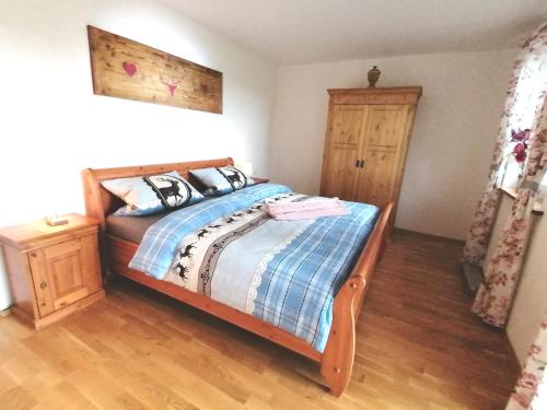 a bedroom with a bed with a blue and white comforter at Ferienwohnung Bauer in Böbing
