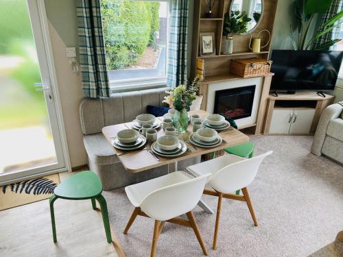 a living room with a table and chairs and a tv at The Sanctuary Holiday Home - Escape the Ordinary in Knaresborough