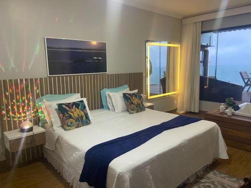 a bedroom with a bed and a large window at Pousada e Restaurante Vista Turquesa in Arraial do Cabo