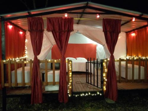1 cama en un cenador con cortinas y luces rojas en Hotel Yamboró, en Pitalito