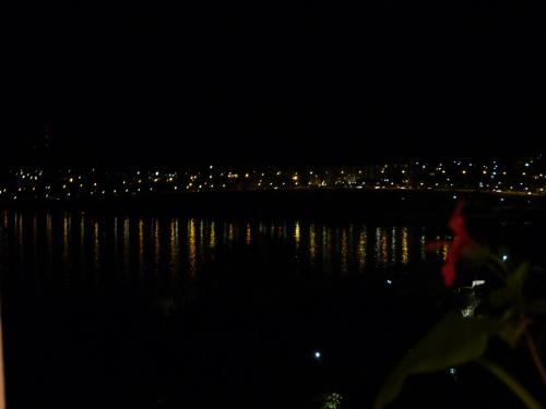 a view of the water at night with a city at Hotel Royal in Colonia del Sacramento