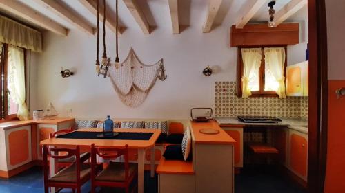 una cocina con armarios naranjas y una mesa con sillas. en Villa Lisa, en Duna Verde