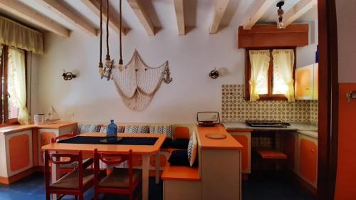 une cuisine avec des armoires orange et une table avec des chaises dans l'établissement Villa Lisa, à Duna Verde