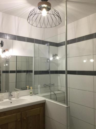 a bathroom with a glass shower and a sink at Appartement centre Barcelonnette in Barcelonnette