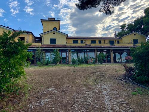 a large yellow building with a tower on top of it at Torre del Gallo in Ripatransone