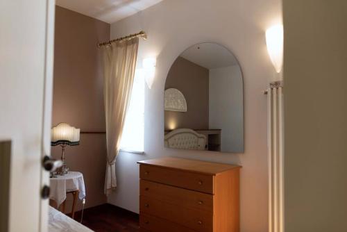 a bedroom with a dresser and a large mirror at Ercole Luxury Flat in Sessa Aurunca