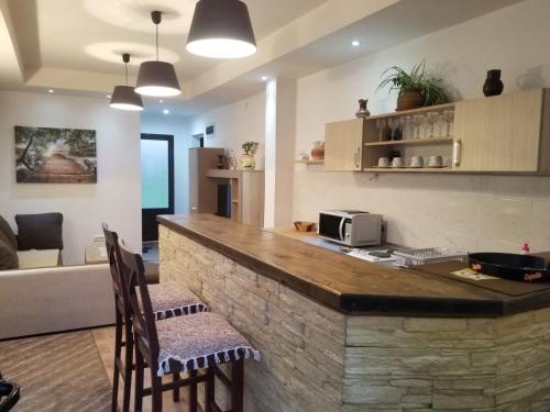 a kitchen and living room with a counter and chairs at Apartments Beka in Žabljak
