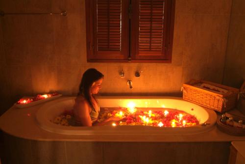 Una mujer en una bañera con velas. en Ocean Beauty en Pereybere