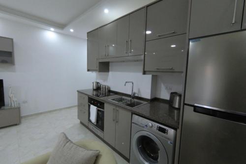 a kitchen with a stainless steel refrigerator and a dishwasher at Executive Apartments in Amman