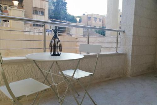 a table and two chairs on a balcony at Executive Apartments in Amman