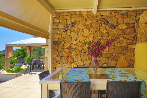 a table with a vase of flowers on a stone wall at Antico Trullo Salentino in Salve