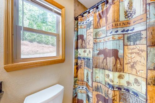 a bathroom with a horse shower curtain and a window at Sun Eagle Lodge in Bryson City