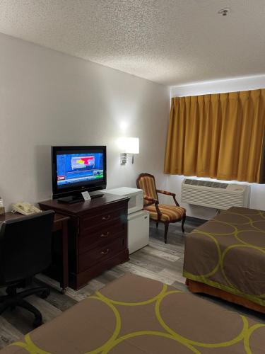 a hotel room with a television and a bed at Super 8 by Wyndham Trinidad in Trinidad