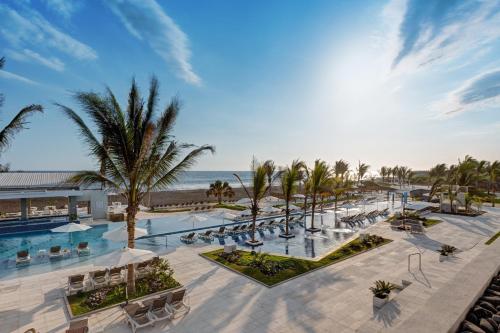 an aerial view of a resort with a pool and palm trees at Oceana Resort & Conventions in Monterrico