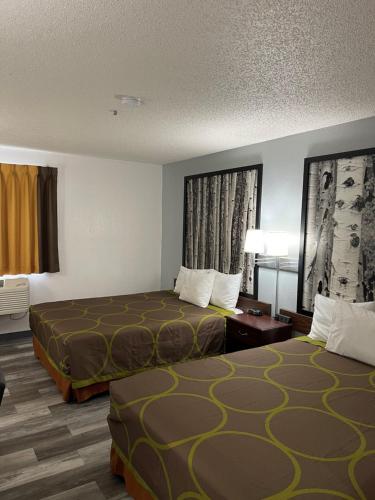 a hotel room with two beds and a table at Super 8 by Wyndham Trinidad in Trinidad