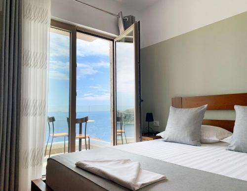 a bedroom with a bed with a view of the ocean at VILA 8 in Himare