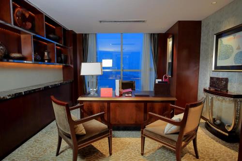 an office with a desk and two chairs and a computer at Crowne Plaza Zhenjiang by IHG in Zhenjiang