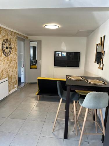 een woonkamer met een tafel en een bank bij Petite maison centre ville in Chartres