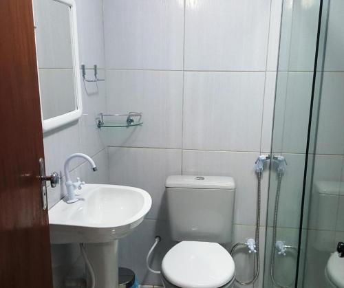 a bathroom with a toilet and a sink and a shower at Flat Visual do Porto in Fernando de Noronha
