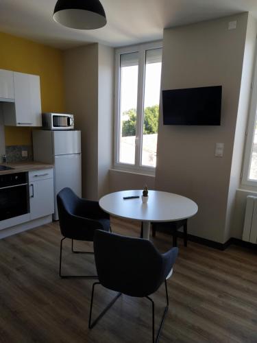 een kamer met een tafel en stoelen en een keuken bij Forges 4 in Saujon