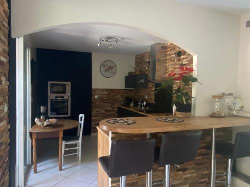 a kitchen with a table and chairs in a room at Villa piscine chauffée & spa sur le Bassin d Arcachon - proche plage et océan in Lanton