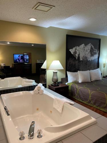 een groot bad in een hotelkamer met een bed bij Super 8 by Wyndham Trinidad in Trinidad
