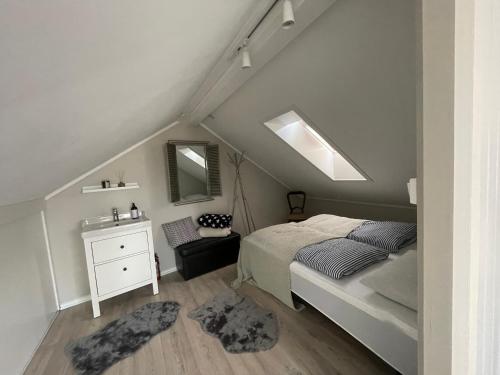 a bedroom with a bed and a dresser and a mirror at Victoriagården in Grimstad