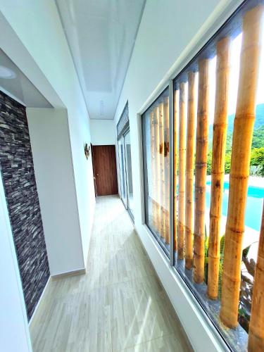 a hallway with windows with a view of the water at Villa Tokyo in Ibagué