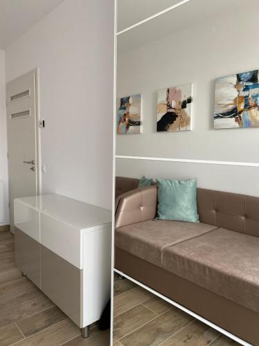 salon z kanapą i obrazami na ścianie w obiekcie ROYAL AQUAMARINE - lakeside luxury flat at Balaton w mieście Keszthely