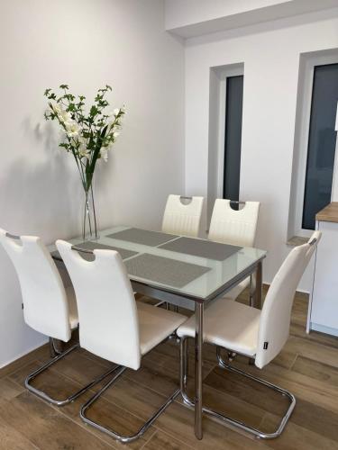凱斯特海伊的住宿－ROYAL AQUAMARINE - lakeside luxury flat at Balaton，一间设有玻璃桌和白色椅子的用餐室