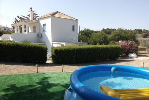 a hot tub in a yard with a house at Olive Grove Soulis Family Estate in Porto Heli