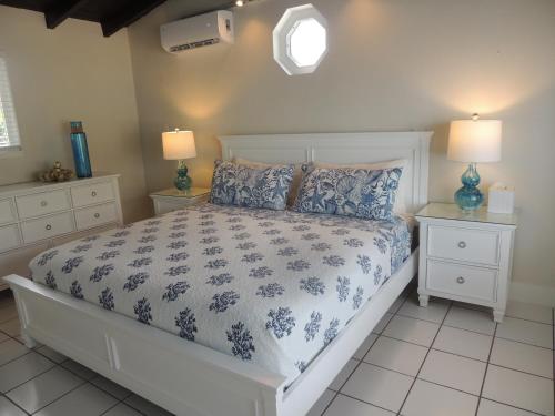 a bedroom with a bed with a blue and white comforter at Sands of Islamorada in Islamorada